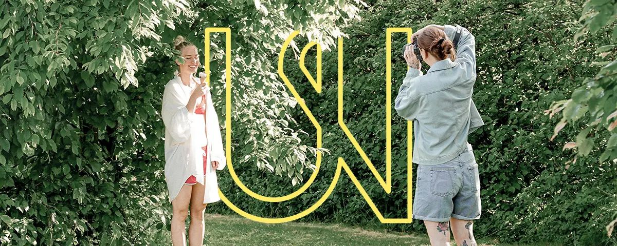 Fotografin fotografiert ein Model im Bademantel vor dichtem Grün mitngWIR. Logo im Hintergrund